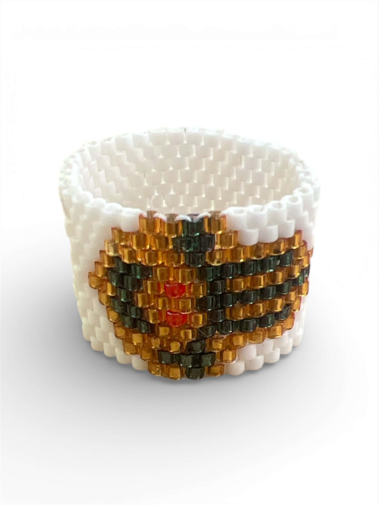 Χειροποίητο δαχτυλίδι Miyuki Peyote με σχέδιο Χάμσα σε λευκό φόντο με χρυσές και πράσινες χάντρες – Axinos Crafts.